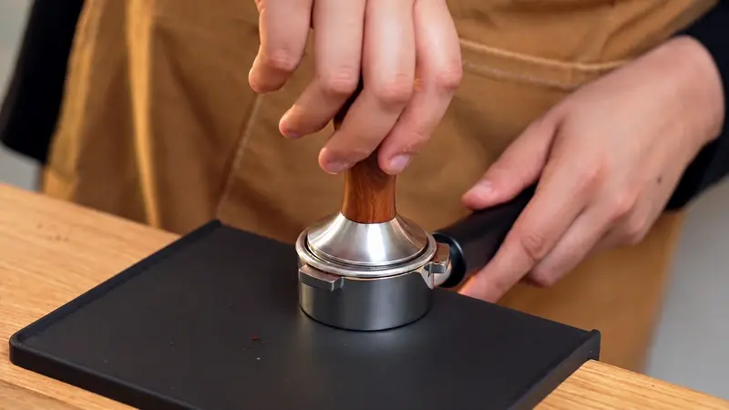 Liz tamping coffee in a portafilter